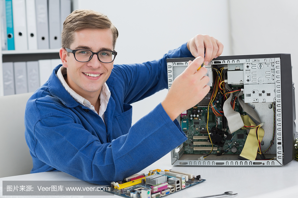 微笑的技术人员在损坏的电脑上工作